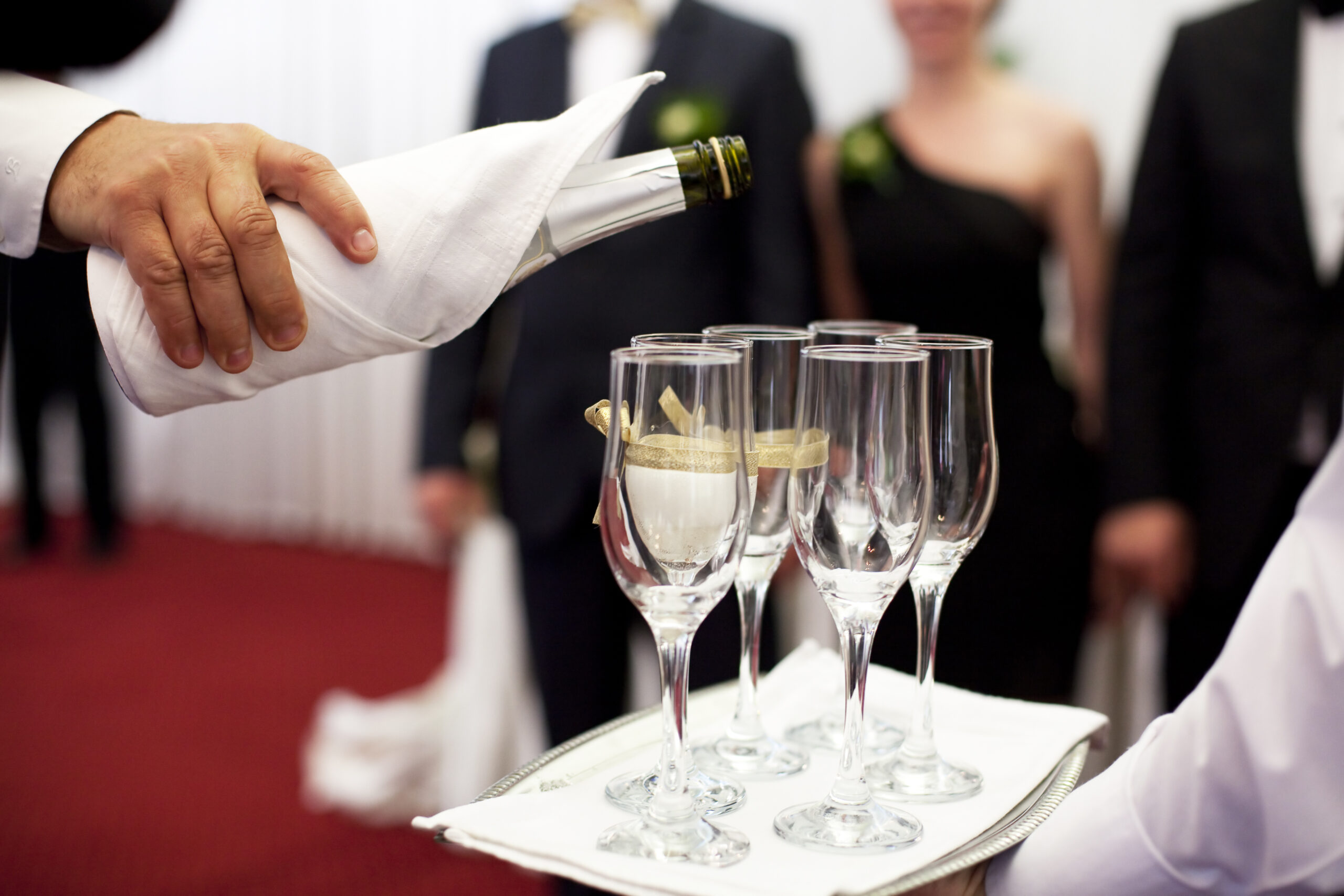 Catering service pouring champagne glasses