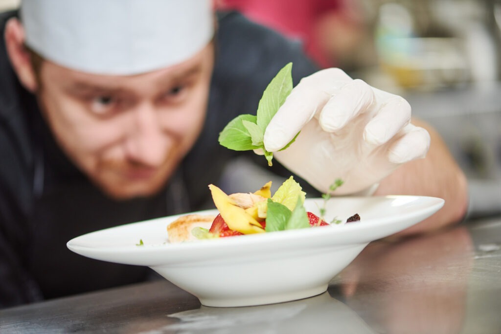 Chef adding finishing touches to gourmet dish